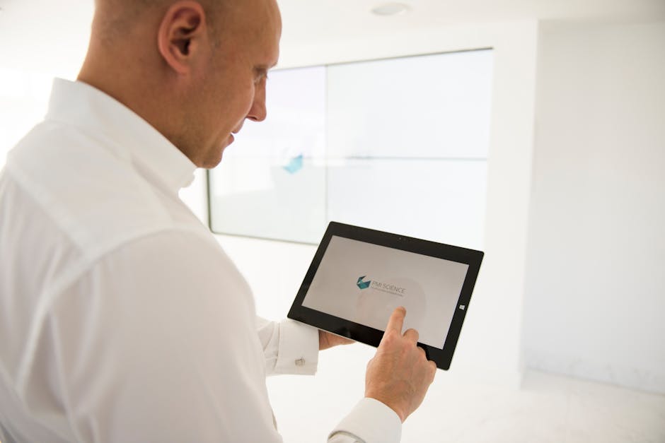 A well-dressed businessman uses a tablet inside a modern office environment